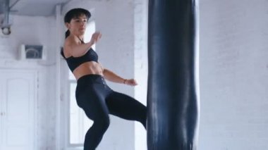 Tekvando profesyonel atlet kadın spor salonunda yumruk torbası tekmeler. Spor salonunda Atletik Kickboks kadın eğitimi.