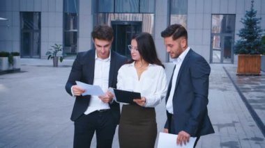 Modern çalışma yaratıcı iş ekibi toplantısı. Start-up fikirlerini tartışan bir grup genç iş adamı, ofis binasının yakınında gülerek, açık havada