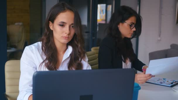 Uttråkad affärskvinna sitter på laptop på kontoret. Trött deprimerad kvinna försöker arbeta på coworking — Stockvideo