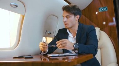 İş adamı Ceo yorgun ve uçakta uçarken başı ağrıyor. Aşırı çalışma konsepti. Zengin bir adam özel bir jetle seyahat eder..