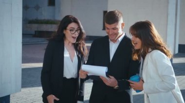 Finansal ve Ekonomik alanlardaki başarılarını kutlamak için tezahürat yapan genç iş adamları. Profesyonel iş adamı ve kadınlar iş hayatında iyi haberler alıyorlar.