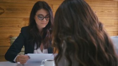 İki iş kadını, konferans masasında oturmuş modern ofiste yeni bir proje planı üzerinde tartışıyorlar. Takım çalışması konsepti.