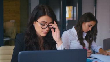 Kavram - işte sorunlar. Ofiste dizüstü bilgisayarın başında oturan sıkıcı iş kadını. Birlikte çalışmaya çalışan bunalımlı bir kadın.