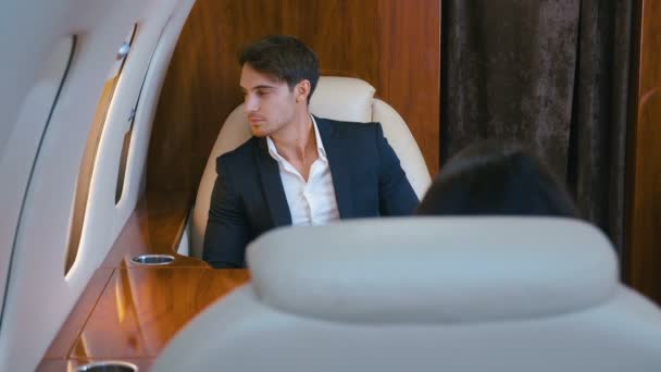 Hombre rico guapo volando en avión jet privado. Young Confident Businessman in Suit Treveling in First Class Airplane (en inglés). El uso de traje clásico . — Vídeo de stock