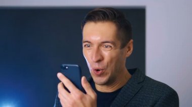 Smartphone 'da Mesaj Okurken İşadamı Başarı Kutlaması. Kişisel hedeflerine ulaşan yakışıklı, profesyonel, başarılı bir adam. Zafer kavramı, zafer..