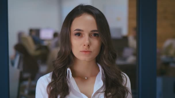 Retrato joven mujer de negocios bonita empresario en camisa blanca mirando a la cámara en el espacio de trabajo de la oficina . — Vídeo de stock