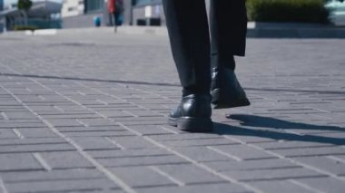 İşe gidip gelen bir iş adamının dikiz ayağında. Deri ayakkabılı ve takım elbiseli kendine güvenen bir adam ofis binasına gidiyor.