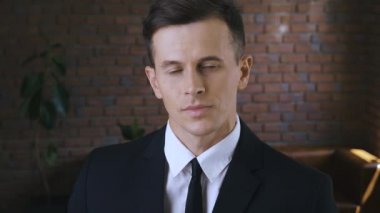 Modern bir ofiste kendinden emin bir iş adamının portresi. Takım elbiseli ve kameraya bakan yakışıklı iş adamı.