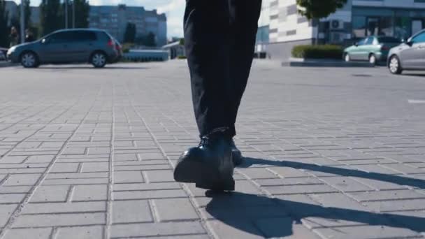Vista frontal pés de homem de negócios comutando para o trabalho. Cara confiante em sapatos de couro e um terno anda ao longo da rua do distrito de negócios — Vídeo de Stock