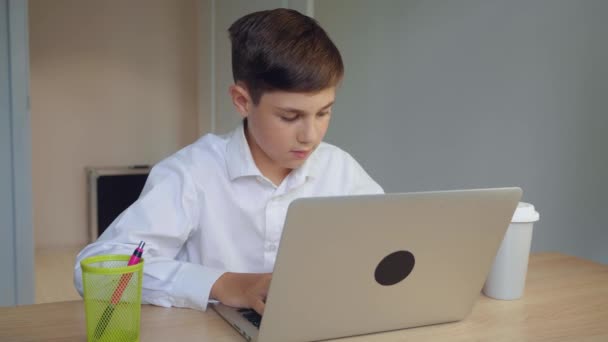 Schöner junger Geschäftsmann arbeitet zu Hause am Laptop und trinkt Kaffee. Online-Lernen, Fernunterricht, Bildung zu Hause. Kind benutzt Laptop-Computer. — Stockvideo