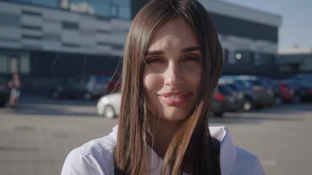 Portrait young attractive smile woman look at camera at city. Close-up of smiling beautiful businesswoman standing near office building — Stock Video