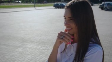 Portre genç, çekici, gülümseyen kadın şehre kamerayla bakıyor. Ofis binasının yanında duran gülümseyen güzel iş kadınının yakın çekimi.