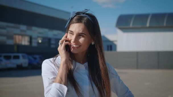 White Shirt 의 Smiling Young Business Woman 은 Modern Office Building 근처의 전화선 외부에서 이야기를 하고 있다. 거리의 옥외에서 휴대 전화로 이야기하는 긴 머리를 가진 매력적 인 여자. — 비디오