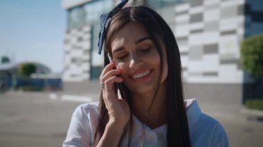 Beyaz Gömlekli Gülümseyen Genç İş Kadını Modern Ofis Binası 'nın önünde telefonda konuşuyor. Uzun Saçlı Çekici Kadın Şehir Caddesinde Dışarda Dururken Cep Telefonuyla Konuşuyor.