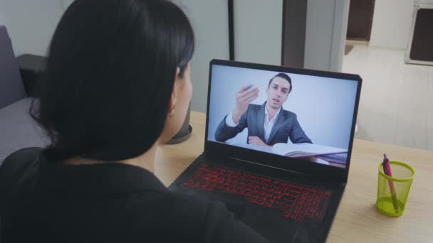 Mujer joven viendo webinar en línea utilizando la llamada de conferencia web portátil en casa . — Vídeos de Stock