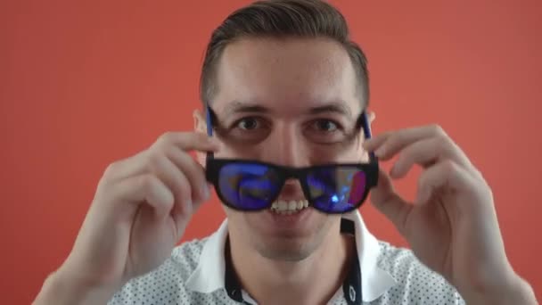 Amazed happy man in surprise shoots sunglasses saying yes celebrating a win. Handsome guy winner surprised to camera over red background. Luck businessman. — Stock Video