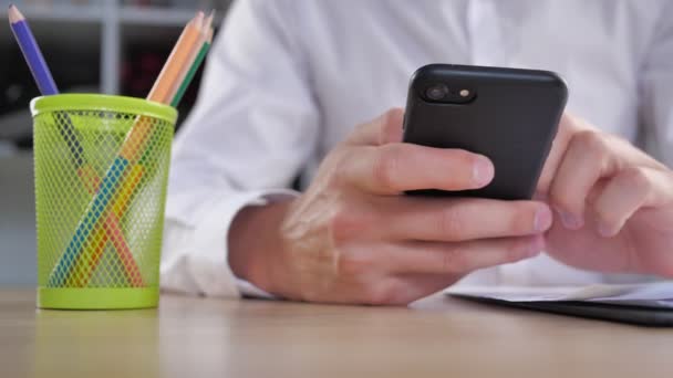 Boze zakenman met een smartphone in zijn handen raakt de tafel met zijn vuist. Stress op het werk — Stockvideo