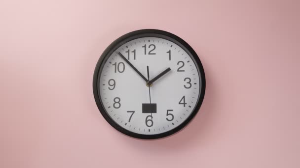 Одиночний білий офісний годинник, що висить на рожевій кольоровій стіні — стокове відео
