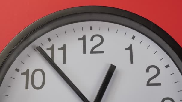 Horloge de bureau close-up accrochée à un mur de couleur rouge — Video