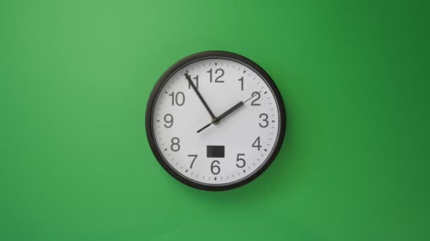 Single white office clock hanging on green background, timelapse — Stock Video