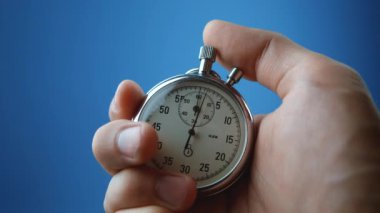 Erkek eliyle yakın plan analog kronometre başlatılıyor ve duruyor