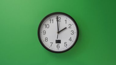 Yeşil arka planda asılı tek beyaz ofis saati