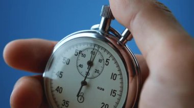 Erkek eliyle yakın plan analog kronometre başlatılıyor ve duruyor