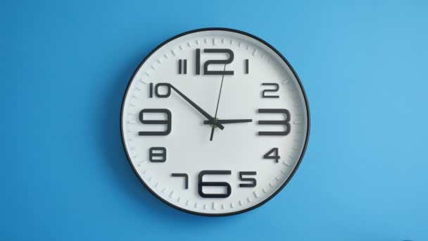 Bílé kancelářské hodiny visící na modré zdi. Včasná — Stock video