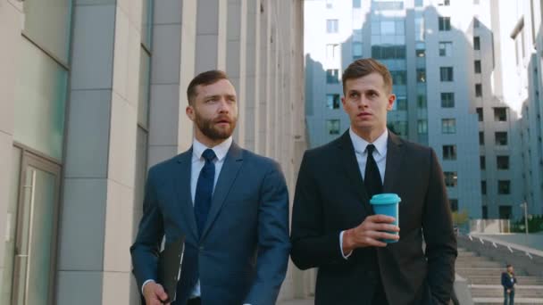 Deux gestionnaires de bureau se rendent au travail et interagissent entre eux. Des hommes d'affaires marchent au centre-ville et discutent d'idées de création d'entreprise. — Video