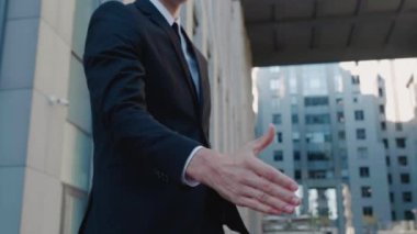 İş adamlarının el sıkışması. Tebrik etme ya da anlaşma sağlama kavramı. İki işadamı modern bir iş binasının arka planında el sıkışıyor..