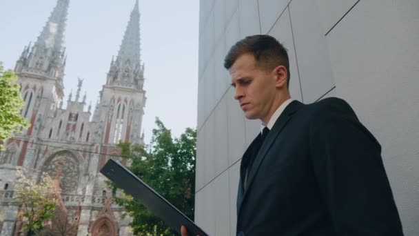 Portrait of a business man examining a contract business contract standing on the street in the business district of the city. Classic suit dressed. — Stock Video