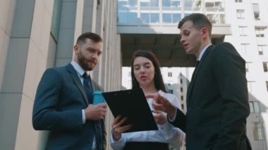 Şehir merkezinde genç iş adamlarıyla toplantım var. Yeni bir işin koşullarının tartışılması. İş ortakları, modern ofis binasının yanında duran başlangıç fikirlerini tartışıyor.