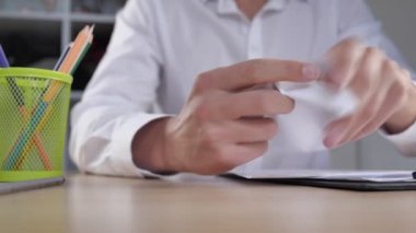Sinirli iş adamlarının yakın plan baskısı iş kağıtlarını yok ediyor ve yumruğunu masaya vuruyor. İş yeri saldırganlığı. İş yerinde sinir krizi konsepti.
