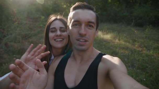 Jeune couple dans la forêt vierge faire un appel vidéo et prendre selfie cool sur le coucher du soleil — Video