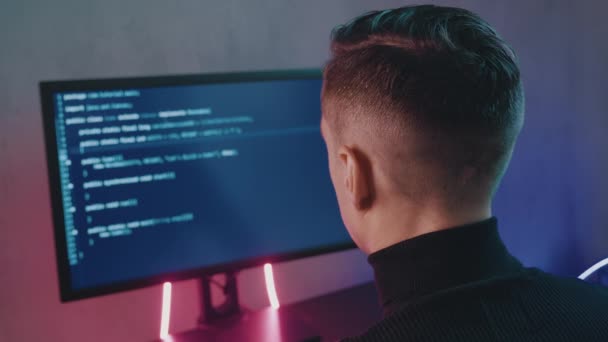L'uomo programmatore professionista sta digitando codice. Sviluppatore al lavoro al computer. Hacker hackerare a tarda notte in luci al neon. — Video Stock