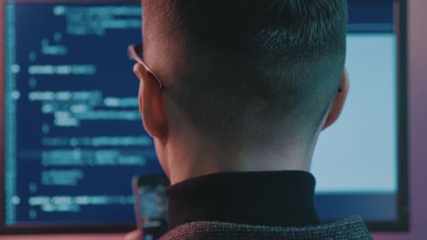 인간 프로그래머가 네온 라이트로 실내의 보안 소프트웨어를 코딩하는 모습. 어두운 사무실에서 컴퓨터 화면으로 코드를 입력하는 해커 — 비디오