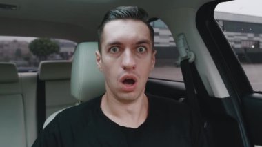 Evet, Kazanan Jest. Bir arabada oturmuş zaferini kutlayan mutlu ve şaşkın bir erkek portresi. Kazanan Genç Adam.