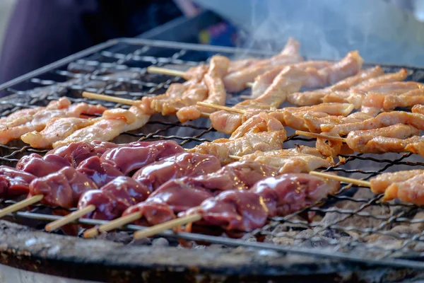 pork skewers and liver chicken skewers is grilling on the grid