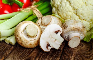 Taze mantar bir kil kase ve maydanoz koyu bir rustik ahşap tablo. Vejetaryen yiyecekler tablodur.