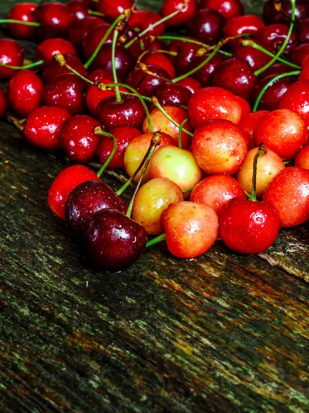 Cherries on wooden table with water drops macro background