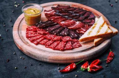 Salam, dilimlenmiş jambon, sosis, jambon, jambon. Taş masada et antipasto tabağı. Kopyalama alanı olan üst görünüm