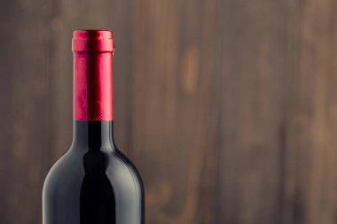 Ahşap arka planda kırmızı şarap şişesi. 