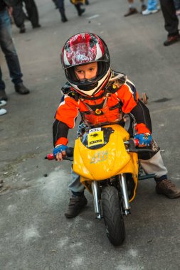 Küçük bir motorcu çocuk motosiklet motosiklet korunmasında bir yetişkin büyük motosiklet bir bisikletçinin festivalinde yanında duruyor. Çocuklar mini moto