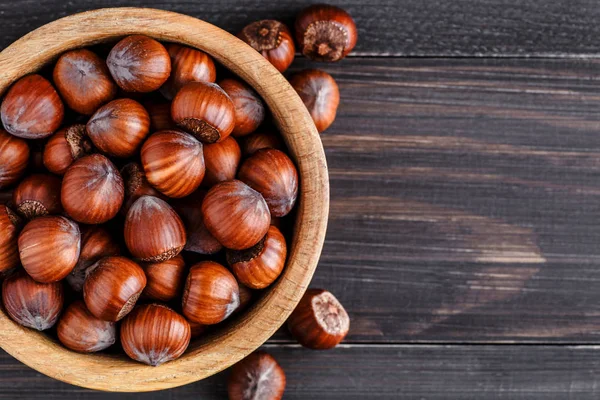 Filtre uygulanan görüntü üzerinde rustik adam ahşap bir kase fındık