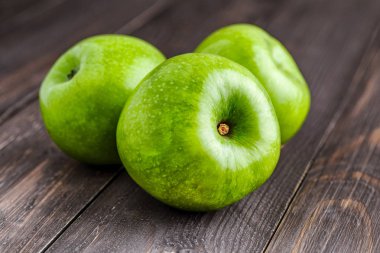 Olgun yeşil elma ve elma dilim eski ahşap zemin üzerine.