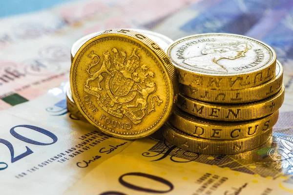 British Pound Coins against a background of British assorted ban