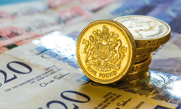 British Pound Coins against a background of British assorted ban
