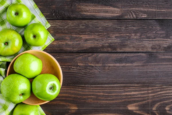 Reife grüne Äpfel und Apfelscheiben auf altem Holzgrund. pla — Stockfoto