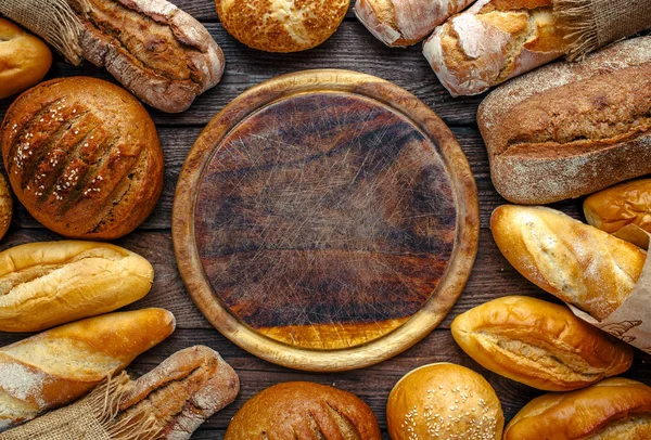 Surtido de pan horneado sobre fondo de mesa de madera, vista superior —  Fotos de Stock