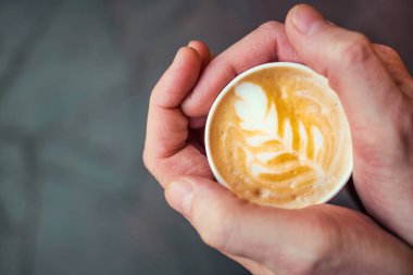 Bir fincan kahve tutan eller.